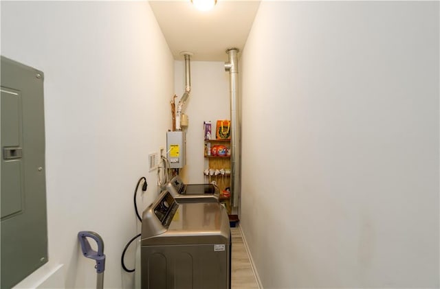 laundry room featuring electric panel, baseboards, light wood-style floors, separate washer and dryer, and laundry area
