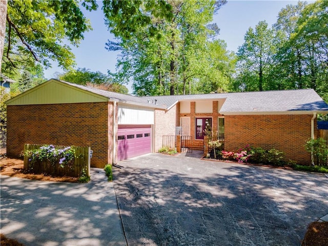 view of front of home with a garage, driveway, and brick siding