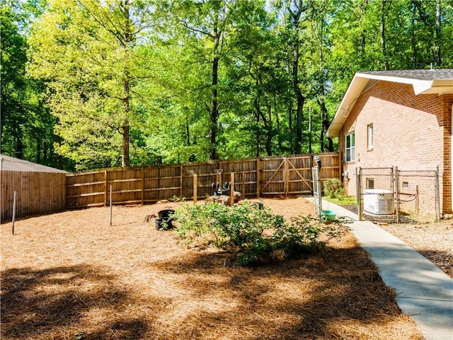 view of yard with a gate and a fenced backyard