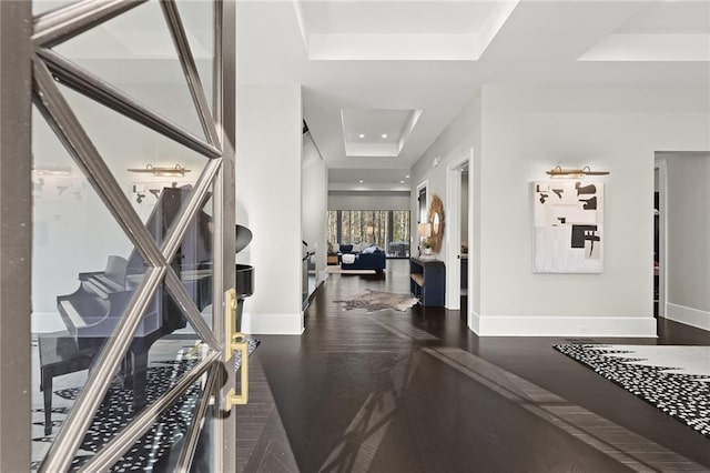 entrance foyer with dark hardwood / wood-style flooring and a tray ceiling