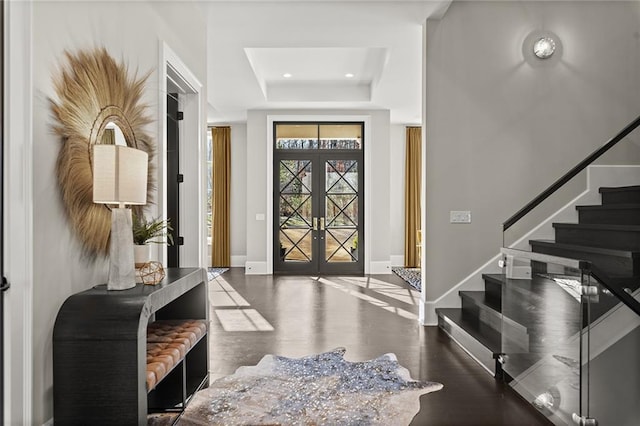 entryway featuring french doors and a raised ceiling