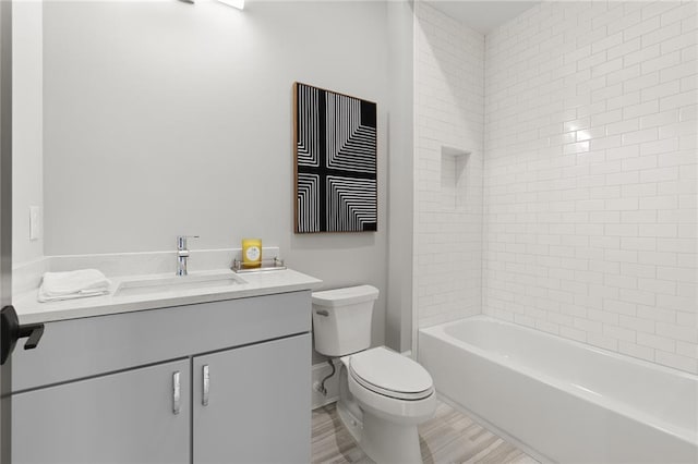 full bathroom featuring toilet, tiled shower / bath combo, and vanity