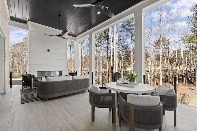 sunroom with ceiling fan, plenty of natural light, and wood ceiling