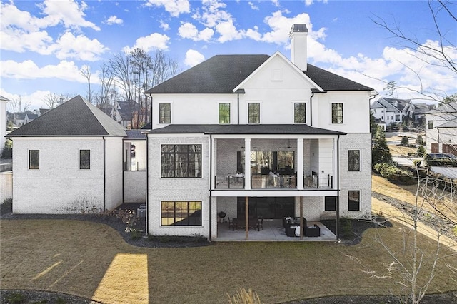 back of house with a lawn, a balcony, and a patio