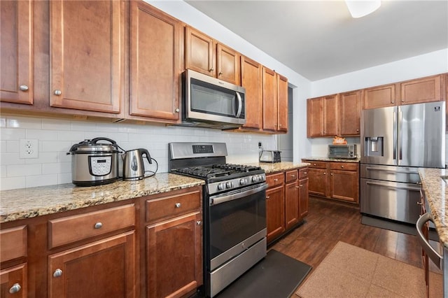 1612 Nations Trl, Riverdale, GA 30296 - kitchen featuring backsplash, stainless steel appliances, brown cabinets, and dark wood-type flooring