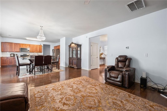 1612 Nations Trl, Riverdale, GA 30296 - living area featuring baseboards, dark wood finished floors, a chandelier, and visible vents