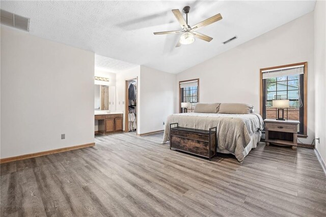 bedroom with visible vents, multiple windows, light wood-style floors, and lofted ceiling