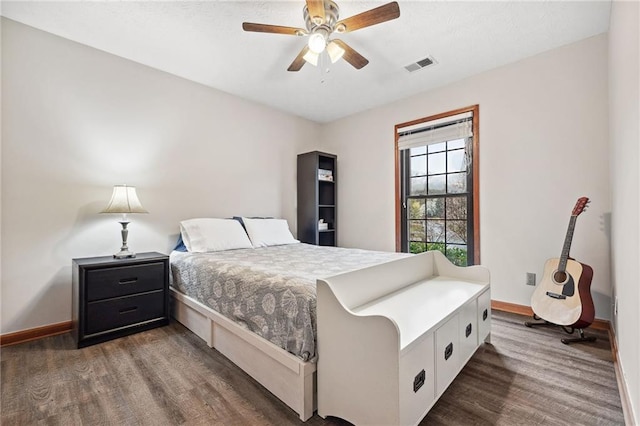 bedroom with visible vents, ceiling fan, baseboards, and wood finished floors