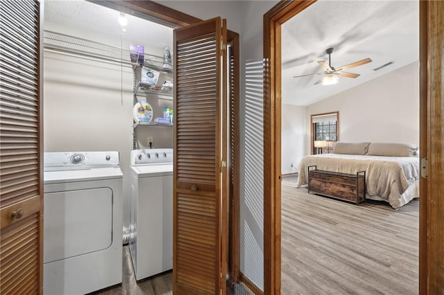 laundry area featuring washing machine and clothes dryer, visible vents, laundry area, wood finished floors, and a ceiling fan