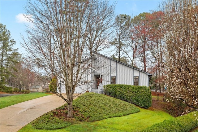 view of property exterior with a yard and driveway