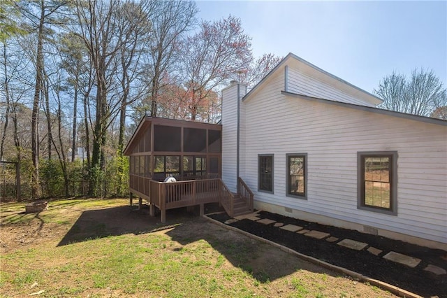 rear view of property with crawl space, a lawn, a chimney, and a sunroom