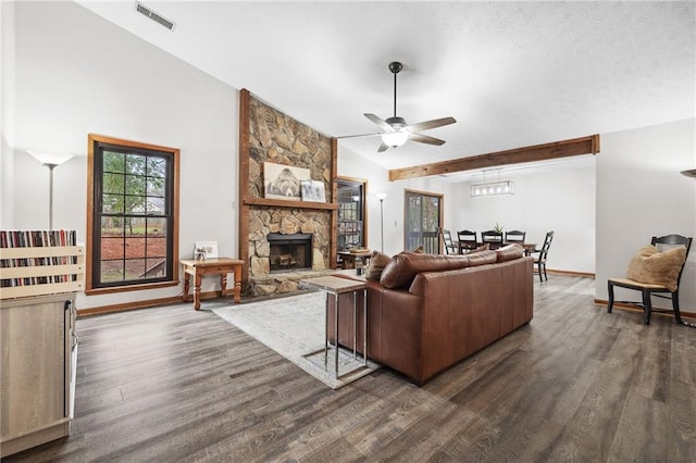 living room with visible vents, baseboards, lofted ceiling with beams, a fireplace, and dark wood-style flooring