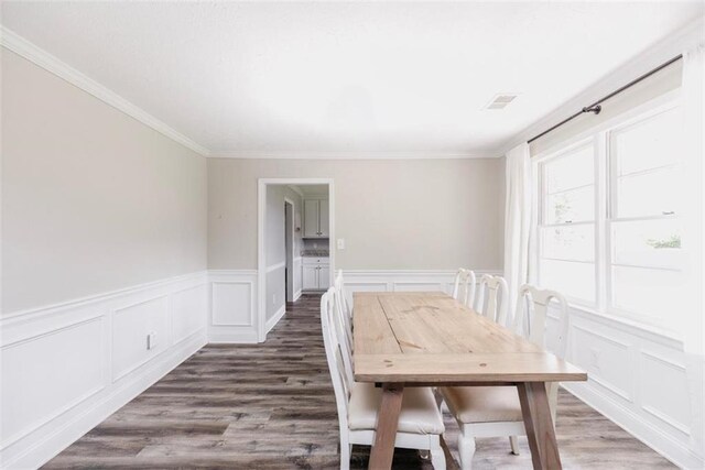 1233 Bethlehem Rd, Statham, GA 30666 - dining room with a decorative wall, ornamental molding, wood finished floors, and wainscoting