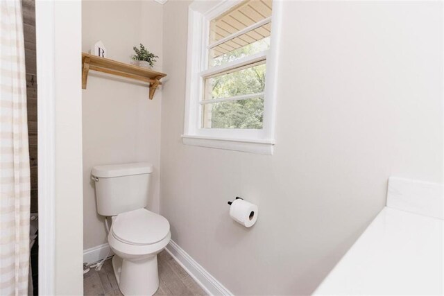 1233 Bethlehem Rd, Statham, GA 30666 - bathroom featuring toilet, baseboards, and wood finished floors