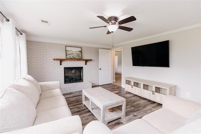 1233 Bethlehem Rd, Statham, GA 30666 - living area featuring crown molding, a brick fireplace, wood finished floors, ceiling fan, and brick wall