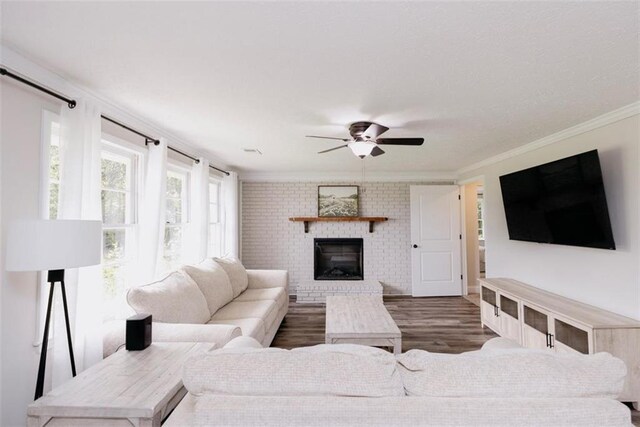 1233 Bethlehem Rd, Statham, GA 30666 - living room featuring crown molding, wood finished floors, a ceiling fan, and a brick fireplace