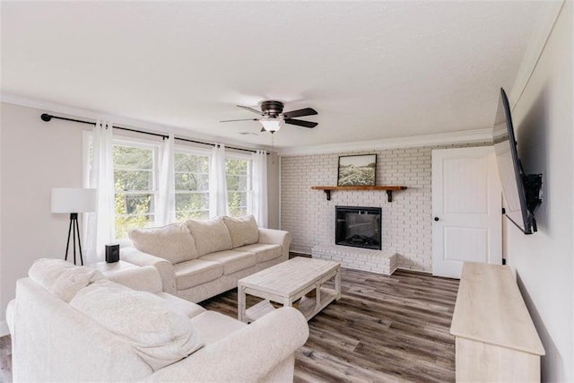 1233 Bethlehem Rd, Statham, GA 30666 - living room featuring ornamental molding, wood finished floors, a brick fireplace, and a ceiling fan