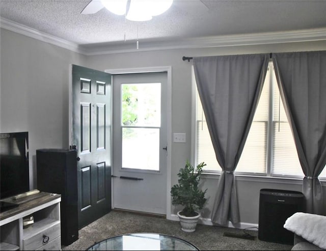 interior space with crown molding, a textured ceiling, a ceiling fan, dark colored carpet, and baseboards