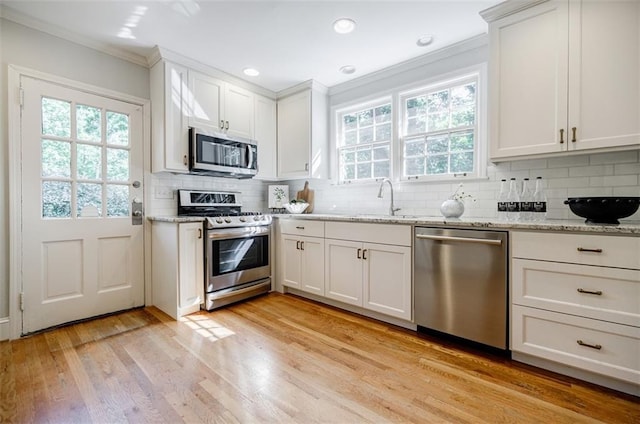 2007 Mount Vernon Pl, Dunwoody, GA 30338 - kitchen featuring stainless steel appliances, crown molding, tasteful backsplash, light wood-type flooring, and white cabinets
