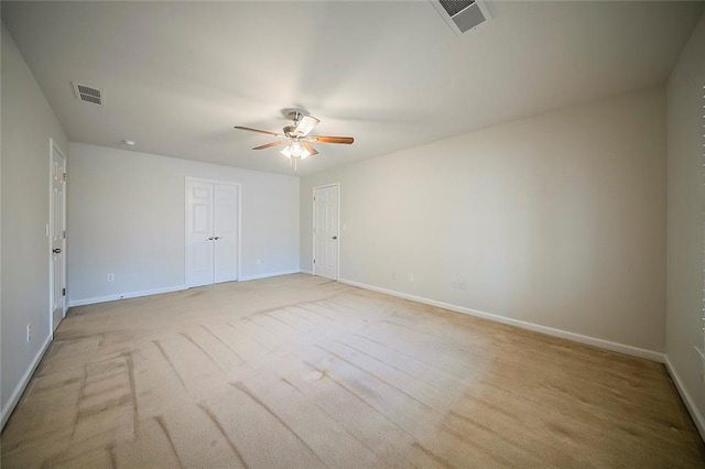 unfurnished room featuring baseboards, visible vents, and ceiling fan