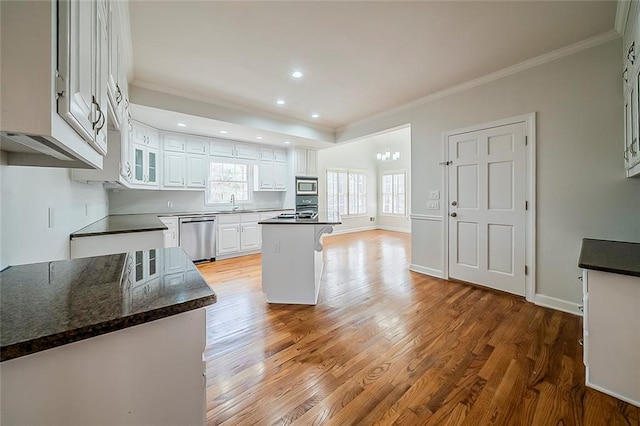 kitchen with white cabinetry, crown molding, light wood finished floors, and appliances with stainless steel finishes