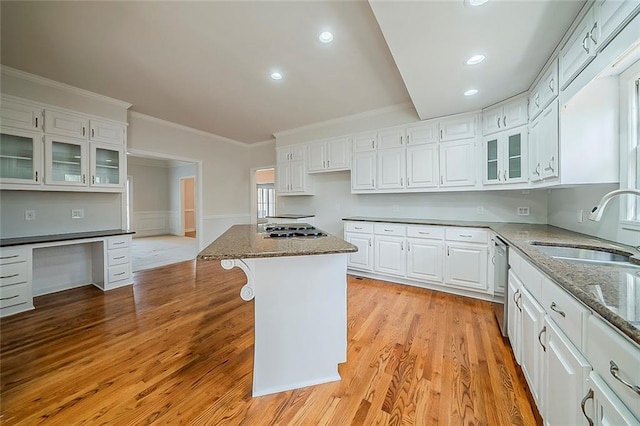 kitchen with a sink, dark stone counters, appliances with stainless steel finishes, and white cabinetry