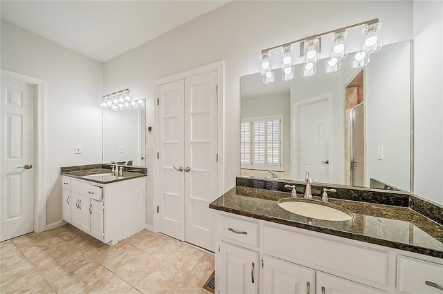 full bathroom featuring a sink, two vanities, a shower stall, and tile patterned flooring