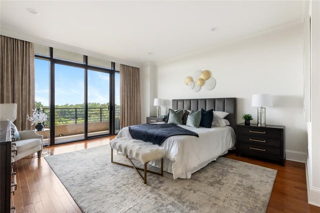 bedroom with expansive windows, dark hardwood / wood-style flooring, crown molding, and access to outside