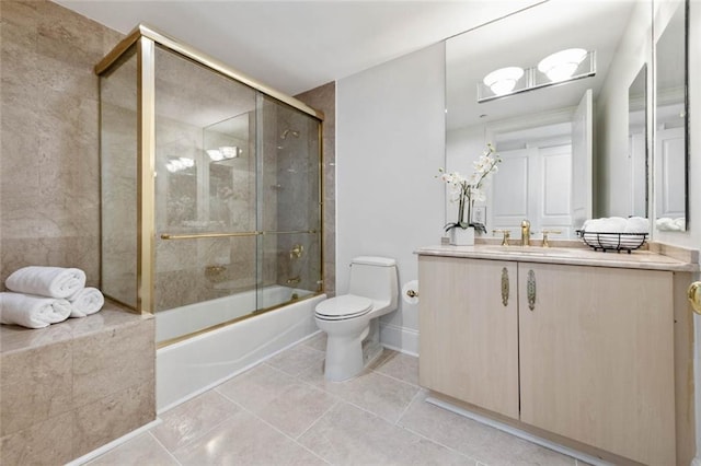 full bathroom with tile patterned flooring, bath / shower combo with glass door, vanity, and toilet