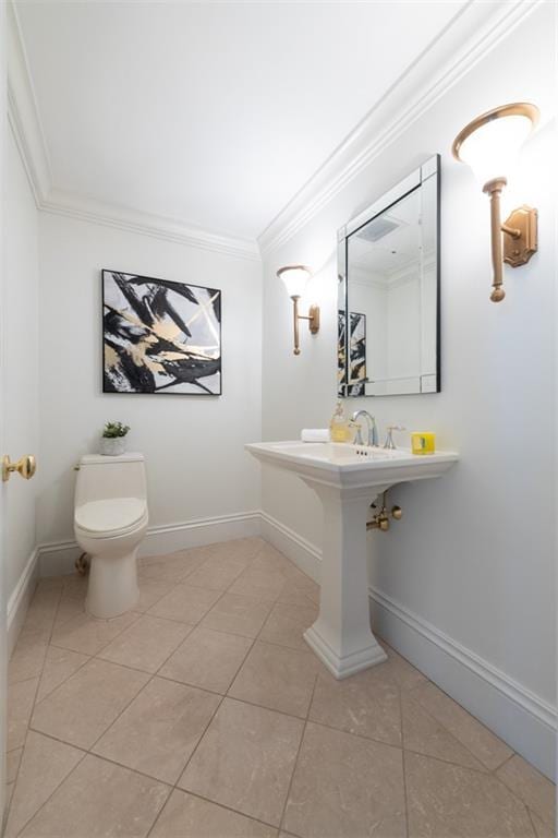 bathroom with tile patterned flooring, crown molding, and toilet