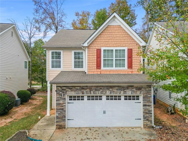 traditional-style house featuring stone siding, roof with shingles, and an attached garage