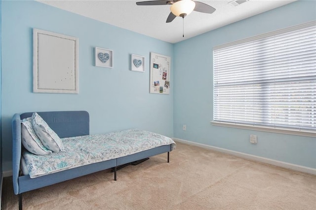 bedroom with a ceiling fan, multiple windows, baseboards, and carpet flooring