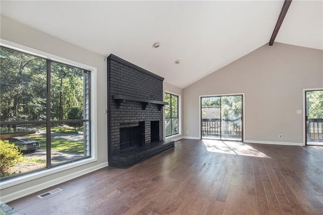 unfurnished living room featuring lofted ceiling with beams, a brick fireplace, and dark wood-type flooring