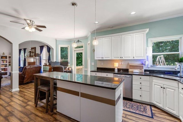 kitchen with dishwasher, sink, plenty of natural light, decorative backsplash, and white cabinets