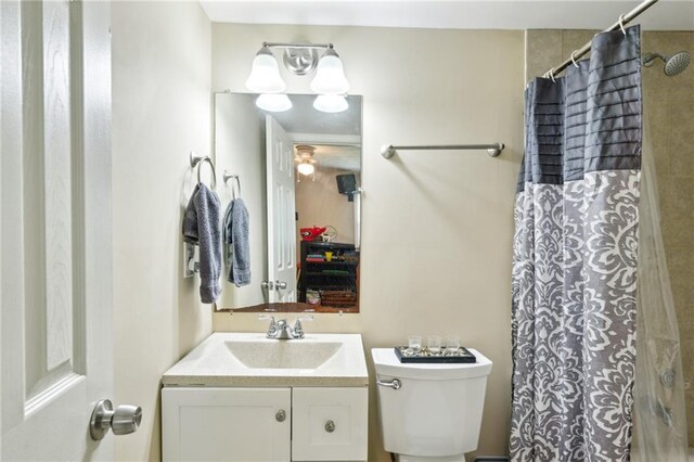 full bath featuring toilet, vanity, and a shower with shower curtain