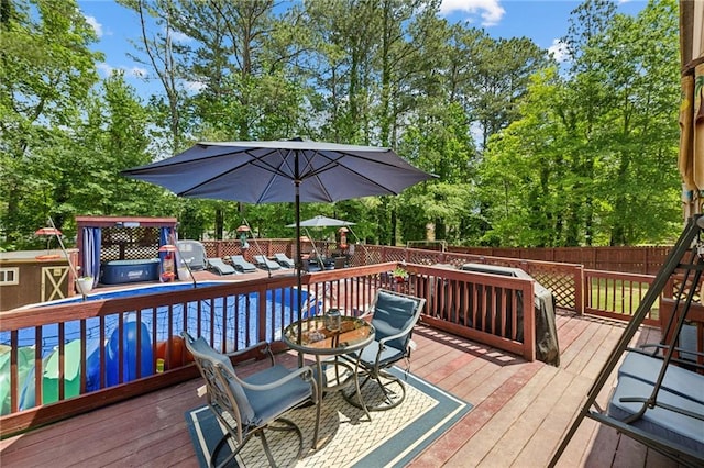 wooden terrace with a fenced backyard, outdoor dining space, and view of scattered trees