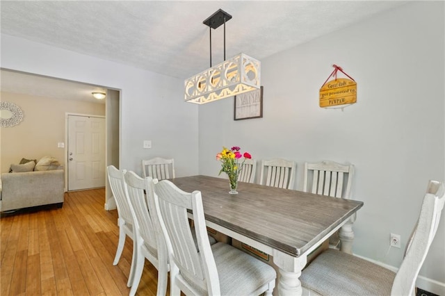 dining space with light wood-style floors and baseboards