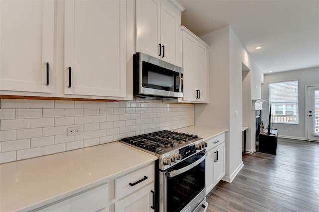 kitchen featuring white cabinetry, tasteful backsplash, stainless steel appliances, and light hardwood / wood-style floors