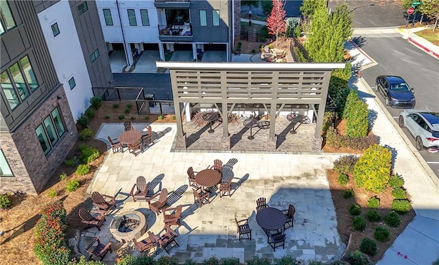 view of community featuring a patio and a fire pit