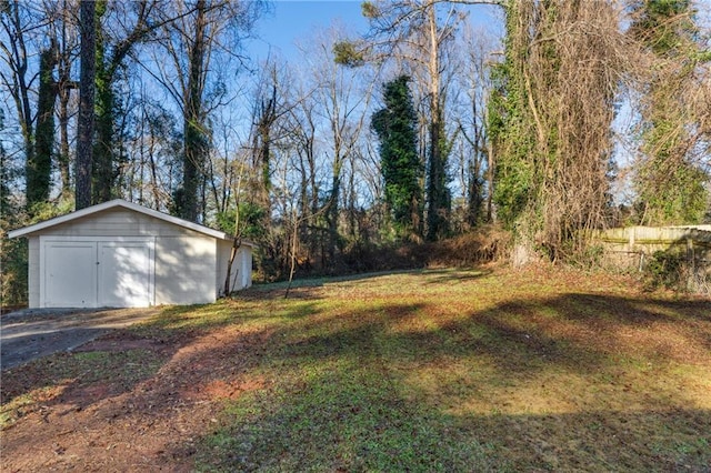 view of yard featuring a garage and an outbuilding