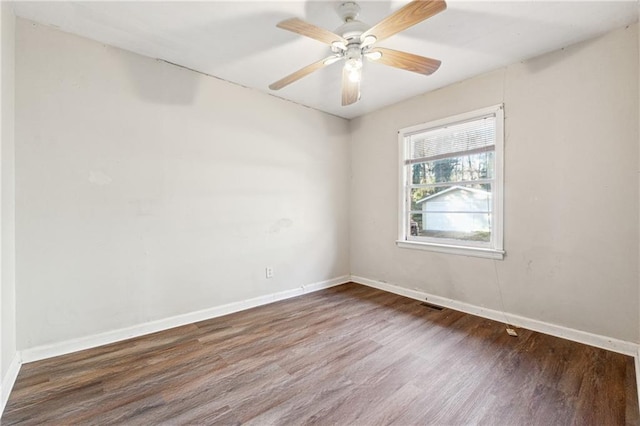 empty room with dark hardwood / wood-style floors and ceiling fan