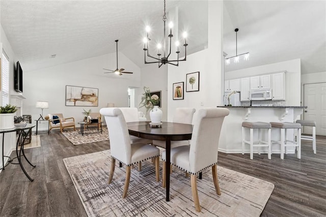 dining area with dark wood-type flooring, ceiling fan with notable chandelier, and high vaulted ceiling