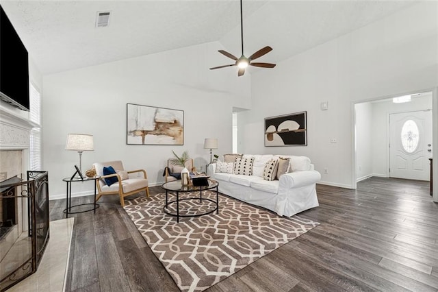 living room with ceiling fan, dark hardwood / wood-style flooring, and high vaulted ceiling