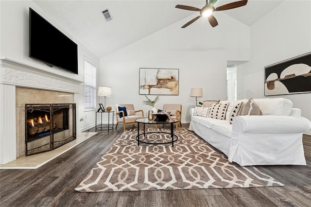 living room with wood-type flooring, high vaulted ceiling, ceiling fan, and a fireplace