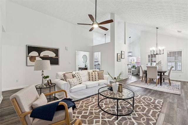 living room featuring dark wood-type flooring, high vaulted ceiling, ceiling fan with notable chandelier, and a textured ceiling