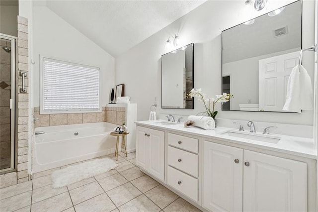 bathroom featuring tile patterned flooring, vaulted ceiling, independent shower and bath, and vanity