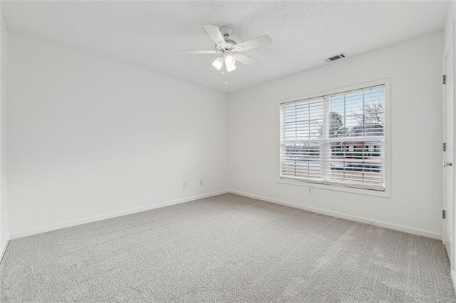 carpeted spare room featuring ceiling fan