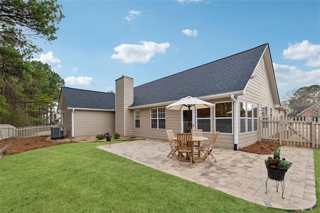 rear view of property with cooling unit, a patio area, and a lawn