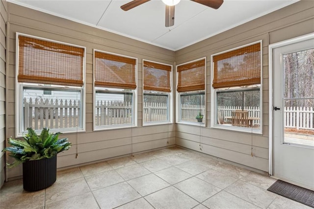 unfurnished sunroom featuring ceiling fan