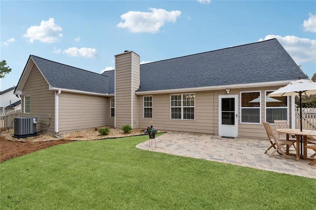 rear view of property featuring a yard, cooling unit, and a patio area